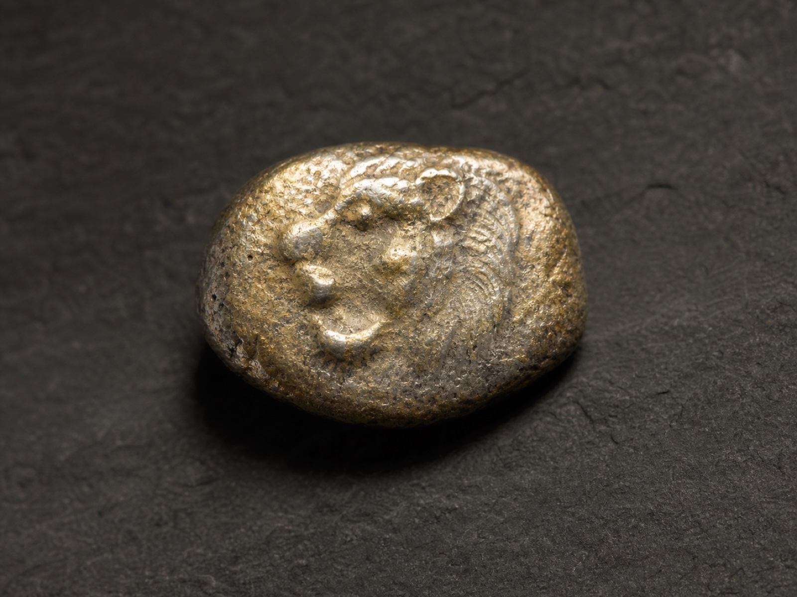 Illustrative reconstruction of an early electrum coin on a museum surface